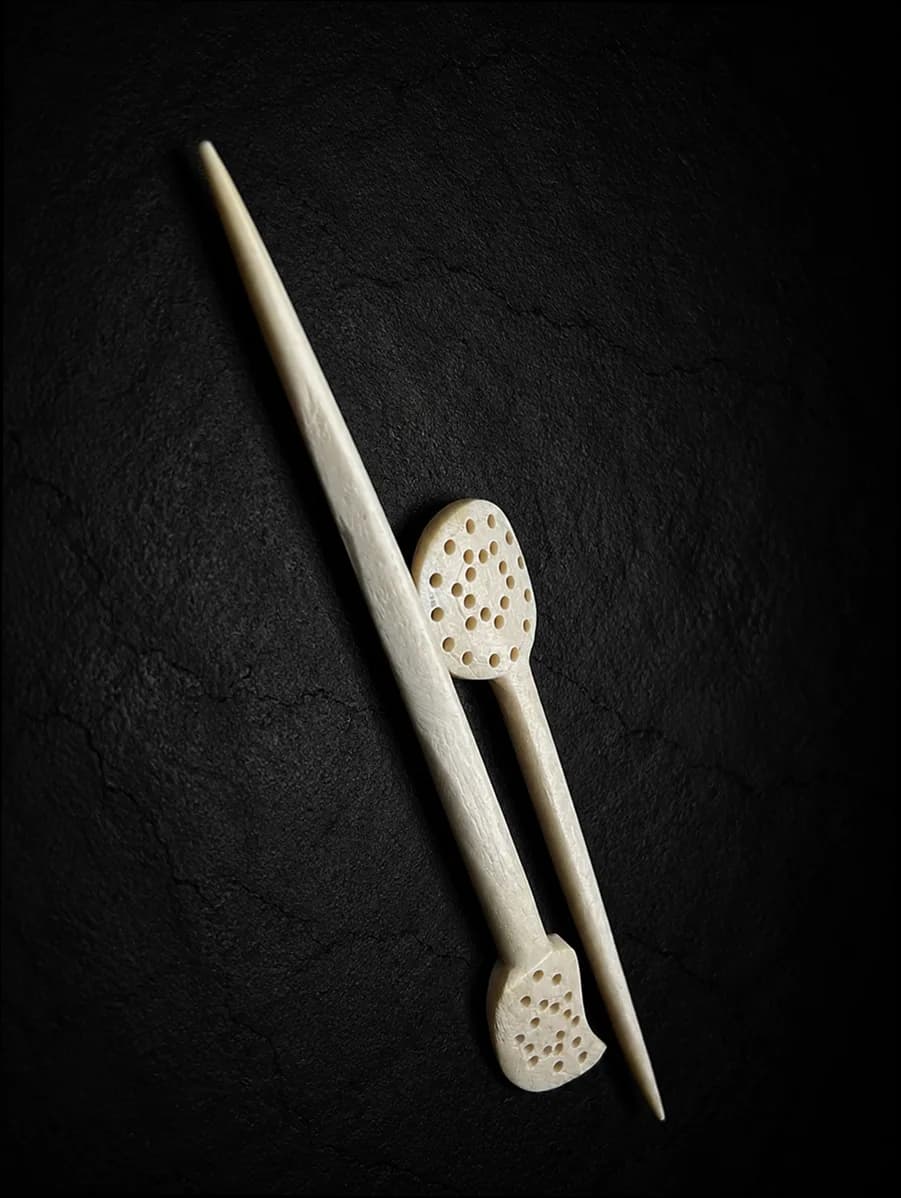 Carved buffalo-bone piece photographed on dark stone (5 of 10)