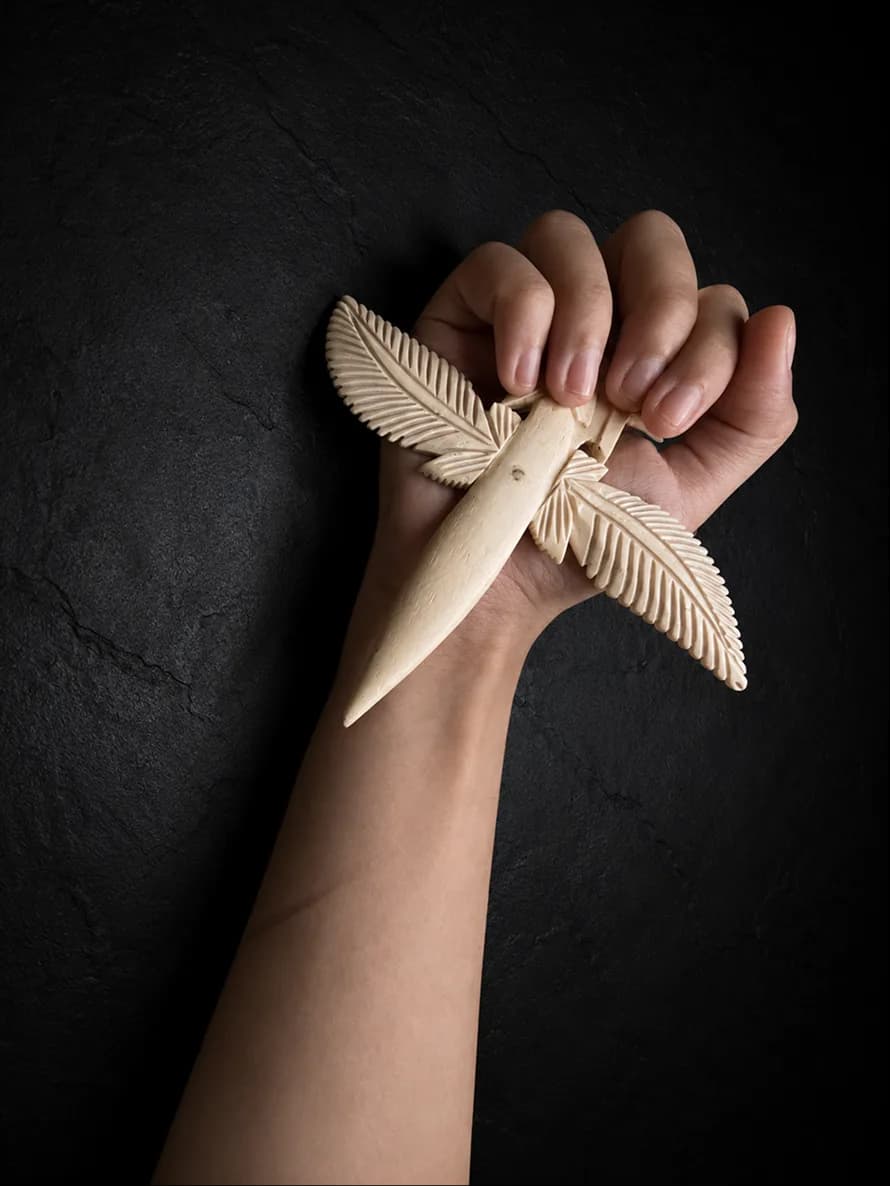 Carved buffalo-bone piece photographed on dark stone (8 of 10)