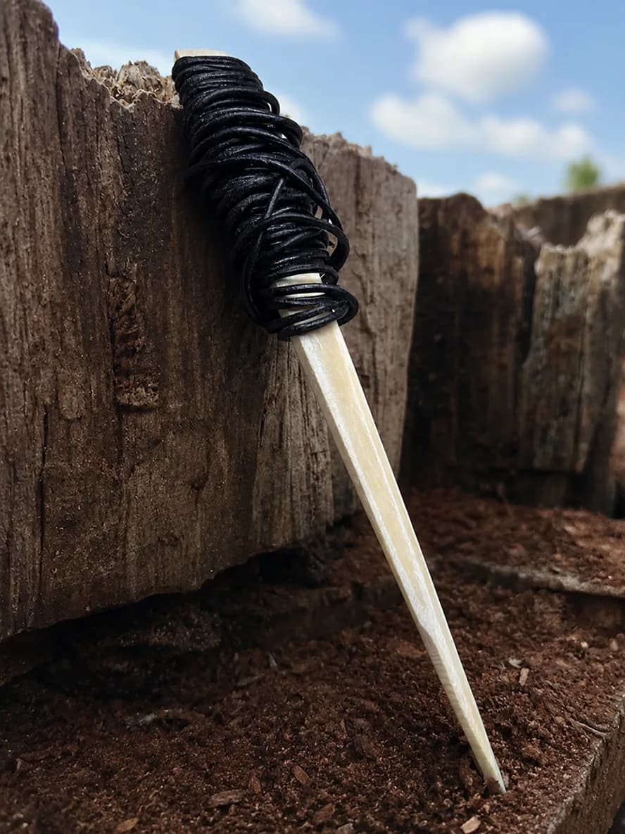 Carved buffalo-bone piece photographed on dark stone (10 of 10)